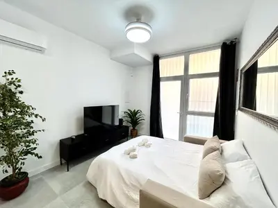 a white bedroom with a bed and a television at Valencia Comfort Stay Near Metro, 2 Bed, 1 Bath in Valencia