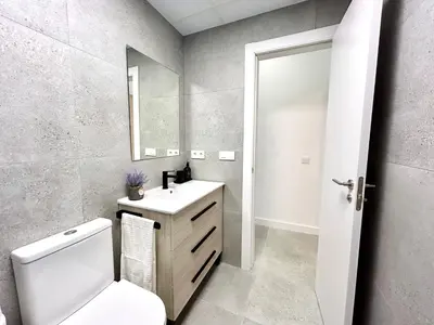 a bathroom with a toilet and a sink and a mirror at Valencia Comfort Stay Near Metro, 2 Bed, 1 Bath in Valencia