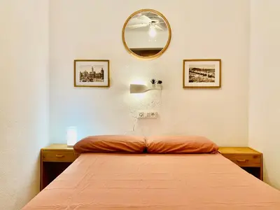 a bedroom with a bed and a mirror on the wall at Batflats-Palmeres Playa in Sueca