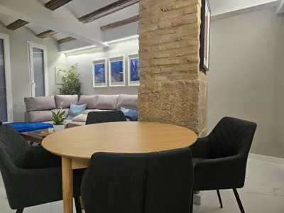 a living room with a wooden table and chairs at eXperience Apartment Valencia in Valencia