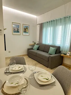 a living room with a table and a couch at Apartamento céntrico cerca de Torres de Serrano y Viveros in Valencia
