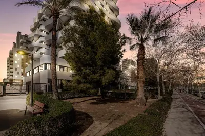 a building with palm trees in front of it at Hotel Arena Select in Valencia