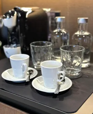 a black counter with two cups and spoons and glasses at Hotel Arena Select in Valencia