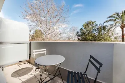 a table and two chairs on a balcony with a window at Hotel Arena Select in Valencia