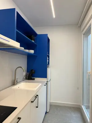 a kitchen with blue and white cabinets and a sink at Apartments Vent de Vela in Valencia