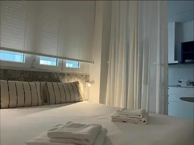 a white bedroom with white towels on a bed at Apartments Vent de Vela in Valencia