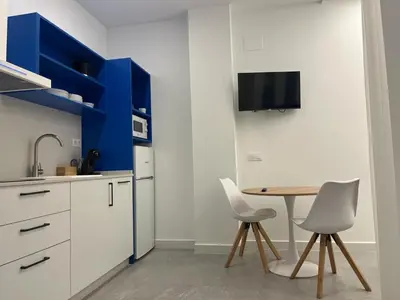 a kitchen with a table and chairs and a refrigerator at Apartments Vent de Vela in Valencia