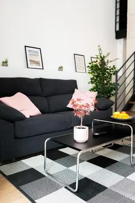 a living room with a black couch and a table at PV Loft Valencia - Modernos y cómodos estudios dúplex cerca a Russafa in Valencia