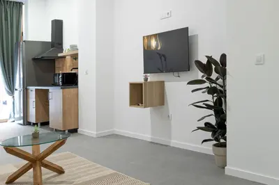 a living room with a table and a kitchen at ESC - Loft Valencia Cómodos y espaciosos estudios cercanos a estación Joaquín Sorolla in Valencia