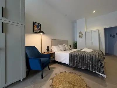 a bedroom with a bed and a blue chair at PALX Loft Valencia - Estudio contemporáneo cerca de las Artes y las Ciencias in Valencia