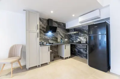 a kitchen with a black refrigerator and a table at PALX Loft Valencia - Estudio contemporáneo cerca de las Artes y las Ciencias in Valencia
