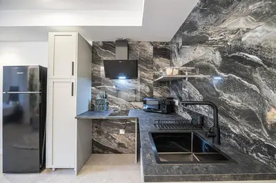 a kitchen with a stone wall with a sink and a refrigerator at PALX Loft Valencia - Estudio contemporáneo cerca de las Artes y las Ciencias in Valencia