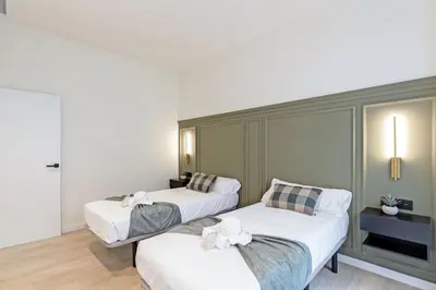 two beds in a room with white sheets at GuestReady - Urban elegance in Valencia in Valencia