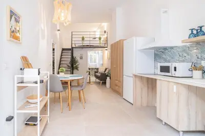 a kitchen and living room with a table and chairs at RM1 - Loft Valencia cómodos estudios dúplex cerca a la Avenida del Puerto in Valencia