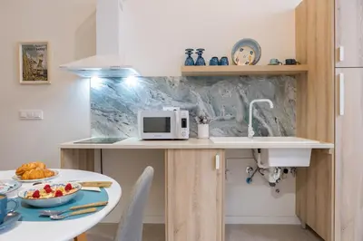 a kitchen with a table and a microwave on a counter at RM1 - Loft Valencia cómodos estudios dúplex cerca a la Avenida del Puerto in Valencia