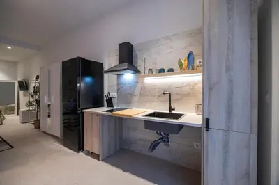 a kitchen with a sink and a black refrigerator at PM - Loft Valencia Espaciosos estudios con terraza cerca a las Artes y las Ciencias in Valencia
