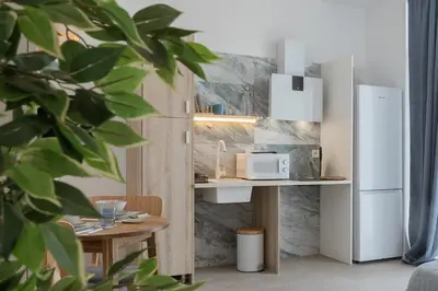 a kitchen with a counter with a microwave and a refrigerator at UY - Loft Valencia Acogedores y modernos estudios cerca de la estación Joaquín Sorolla in Valencia