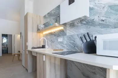a kitchen with a counter with a sink and a microwave at UY - Loft Valencia Acogedores y modernos estudios cerca de la estación Joaquín Sorolla in Valencia