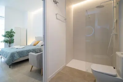a bathroom with a bed and a glass shower at MDB - Loft Valencia Bonito y cómodo estudio cerca a la estación Joaquín Sorolla in Valencia