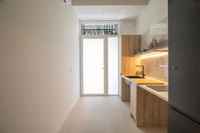 a kitchen with wooden cabinets and a large window at LO - Loft Valencia - Modernos y acogedores estudios cerca a las Artes y las Ciencias in Valencia