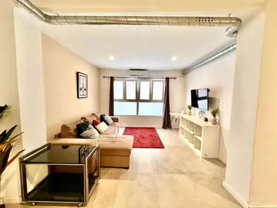 a living room with a couch and a tv at Turia Gardens & Science & Center in Valencia