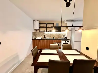 a dining room with a table and chairs and a kitchen at Turia Gardens & Science & Center in Valencia