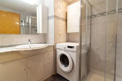 a bathroom with a washing machine and a sink at Global Vacacional, Apartamento de 3 habitaciones en urbanización cerca del mar in Canet de Berenguer
