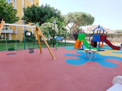 a playground with several slides and a swing set at Global Vacacional, Apartamento de 3 habitaciones en urbanización cerca del mar in Canet de Berenguer