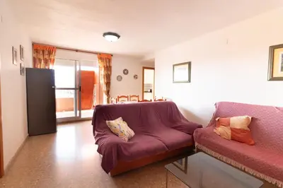 a living room with a couch and a table at Global Vacacional, Acogedor apartamento en Canet de Berenguer in Canet de Berenguer