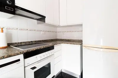 a kitchen with white cabinets and a sink at Global Vacacional, Acogedor apartamento en Canet de Berenguer in Canet de Berenguer