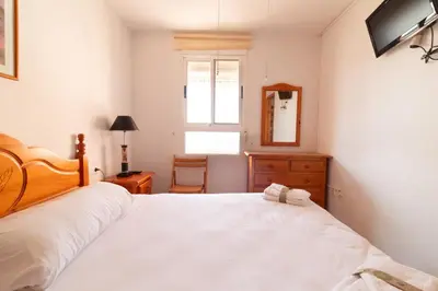 a bedroom with a large white bed and a mirror at Global Vacacional, Acogedor apartamento en Canet de Berenguer in Canet de Berenguer