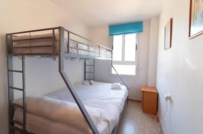a bedroom with two bunk beds and a window at Global Vacacional, Acogedor apartamento en Canet de Berenguer in Canet de Berenguer