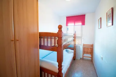 a bedroom with two bunk beds and a window at Global Vacacional, Acogedor apartamento en Canet de Berenguer in Canet de Berenguer