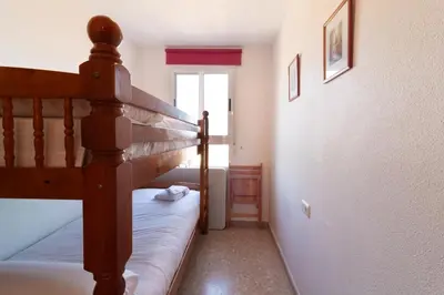 a bedroom with a bunk bed next to a window at Global Vacacional, Acogedor apartamento en Canet de Berenguer in Canet de Berenguer