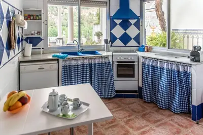 a kitchen with blue and white appliances and a table at La Casa de la Cascada in Anna
