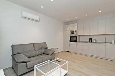 a living room with a couch and a kitchen at GuestReady - One lovely home in Valencia in Valencia
