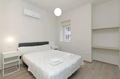 a white bedroom with a bed and a window at GuestReady - One lovely home in Valencia in Valencia