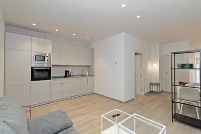 a living room with a couch and a kitchen at GuestReady - One lovely home in Valencia in Valencia