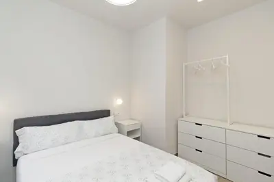 a white bedroom with a bed and a dresser at GuestReady - One lovely home in Valencia in Valencia