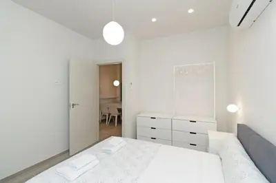 a white bedroom with a bed and a dresser at GuestReady - One lovely home in Valencia in Valencia