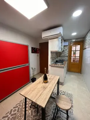 a kitchen with a wooden table and a red wall at Apartamento Oceanografìc in Valencia