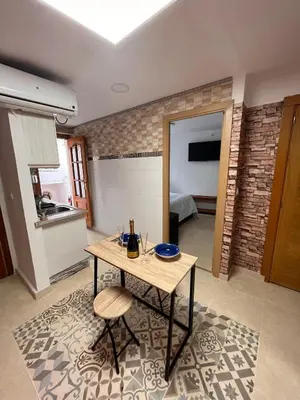 a living room with a table and a kitchen at Apartamento Oceanografìc in Valencia