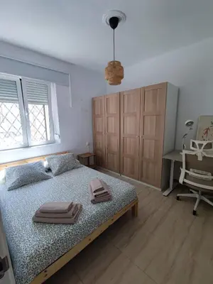 a bedroom with a bed and a desk and a chair at Apartamento al lado de la playa Malvarrosa in Valencia