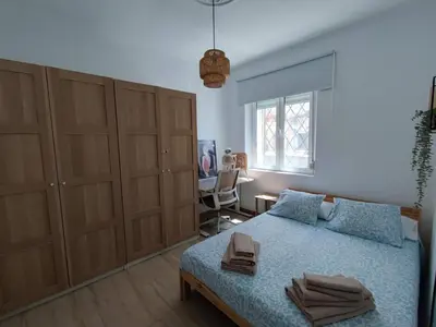 a bedroom with a bed and a desk and a window at Apartamento al lado de la playa Malvarrosa in Valencia