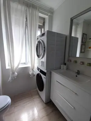 a white bathroom with a washing machine on a counter at Apartamento al lado de la playa Malvarrosa in Valencia