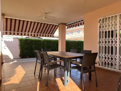 a wooden table and chairs on a patio at Casa Platja Mareny Blau in Mareny Blau
