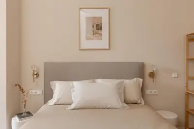 a bed with white pillows and a picture on the wall at MH Apartments Central Valencia in Valencia