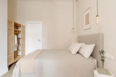 a white bedroom with a bed and a book shelf at MH Apartments Central Valencia in Valencia