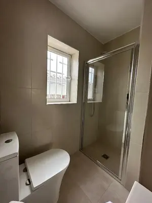 a bathroom with a shower and a toilet and a window at La Casita in La Eliana