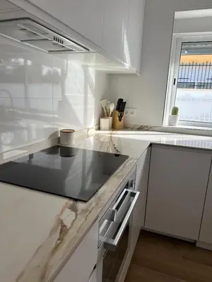 a kitchen with white counters and a stove top oven at La Casita in La Eliana